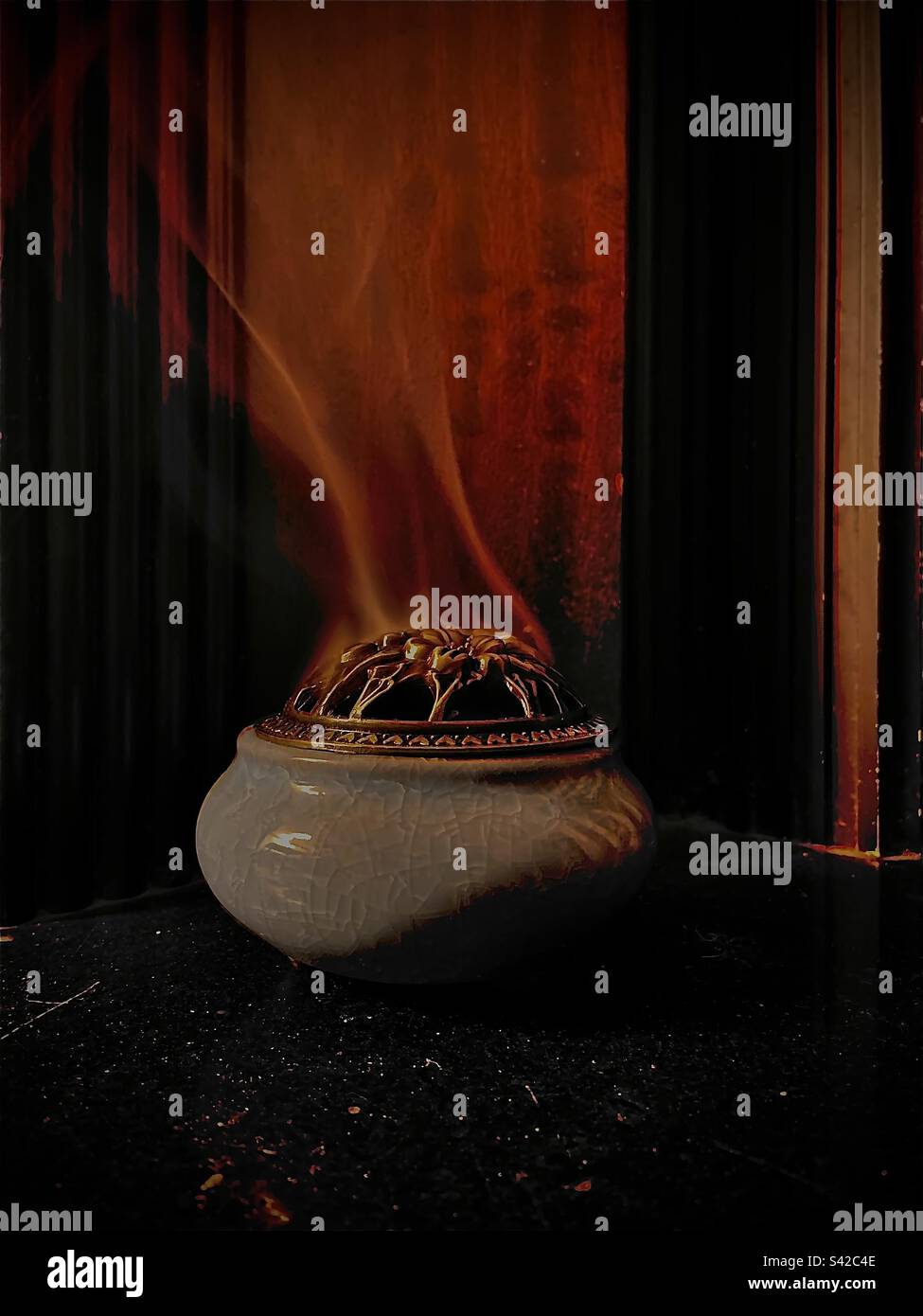 Incense wafting out of its burner in the shape of a person stretching