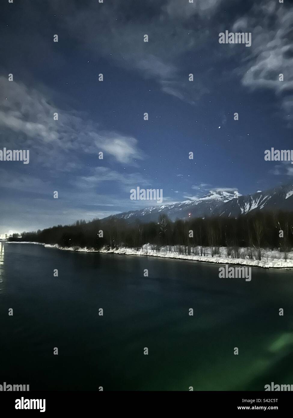 A starry night sky blankets the mountain range with a polka dot of