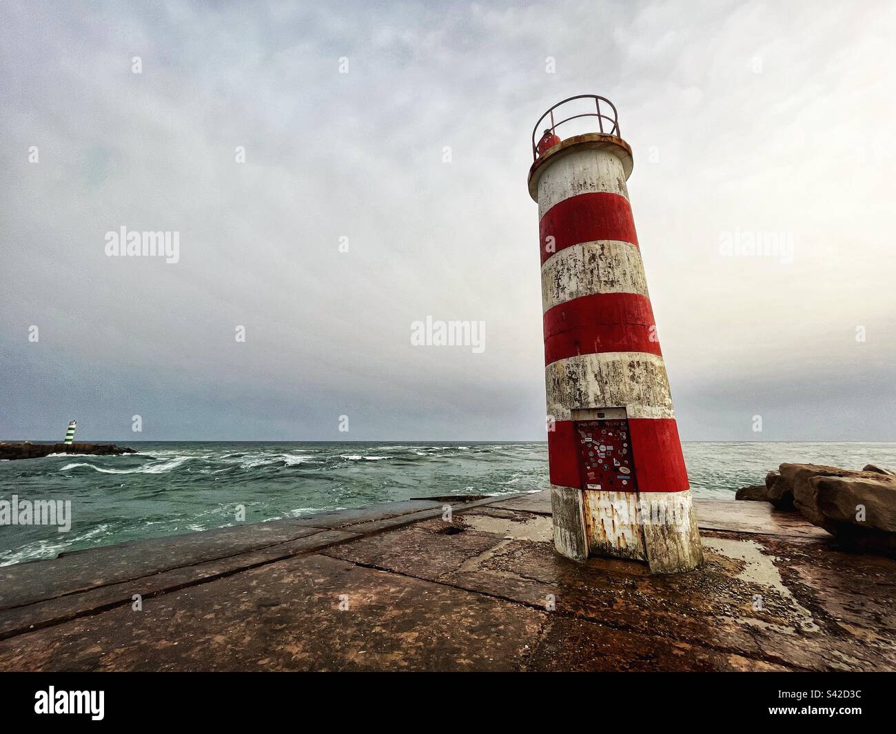 Red striped beacon with green striped beacon - lighthouses - entrance to the Ria Formosa estuary in Portugal near Faro. Atlantic Ocean waves. Ilha Deserta - Smartphone Captured Stock Image
