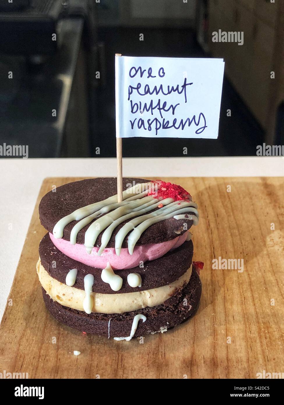 Last one remaining, Solitary Oreo Peanut Butter Raspberry in bakery shop window - Smartphone Captured Stock Image