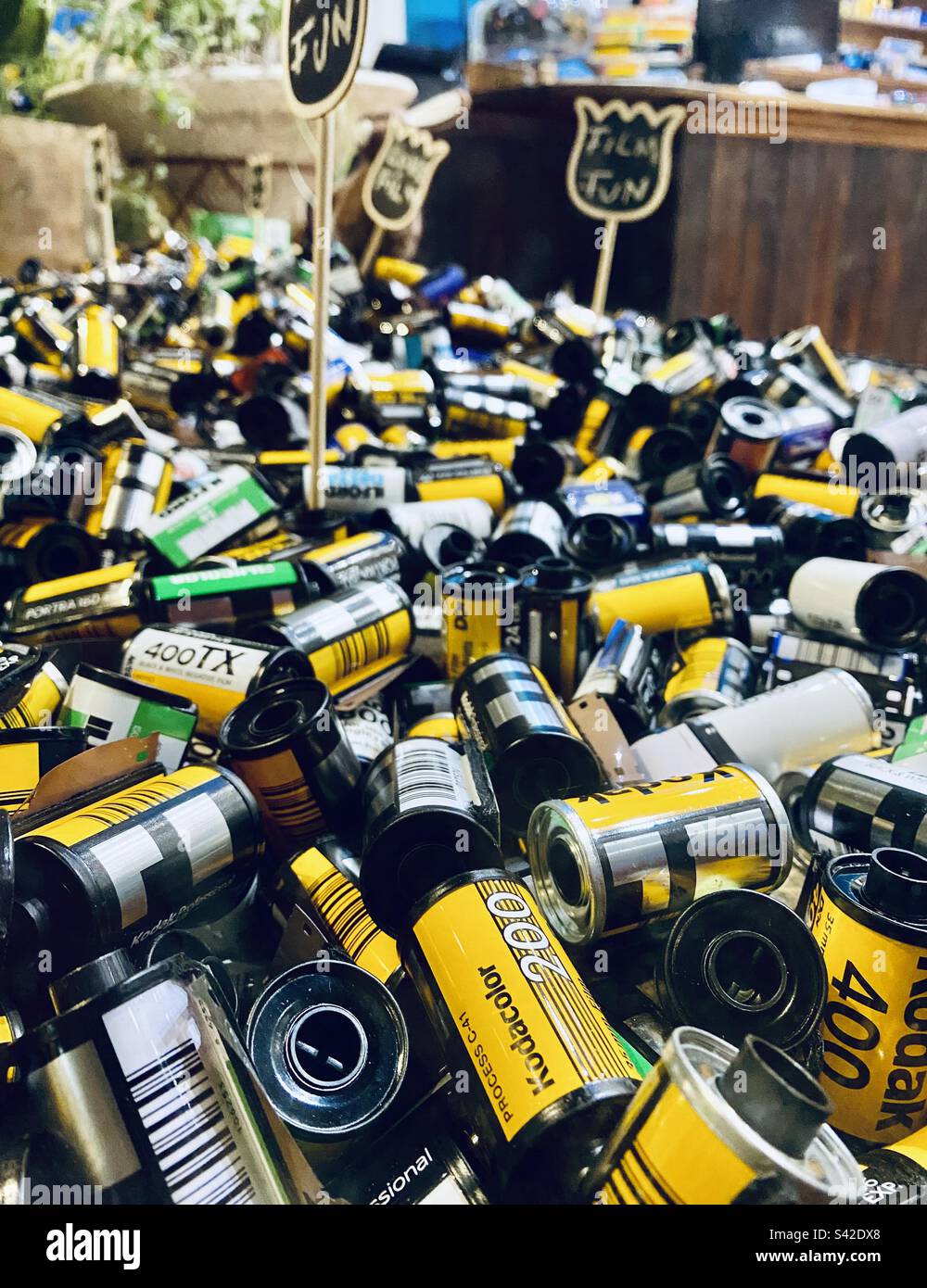 A window display full of old used camera film cases - Smartphone Captured Stock Image A window display full of old used camera film cases - Smartphone Captured Stock Image