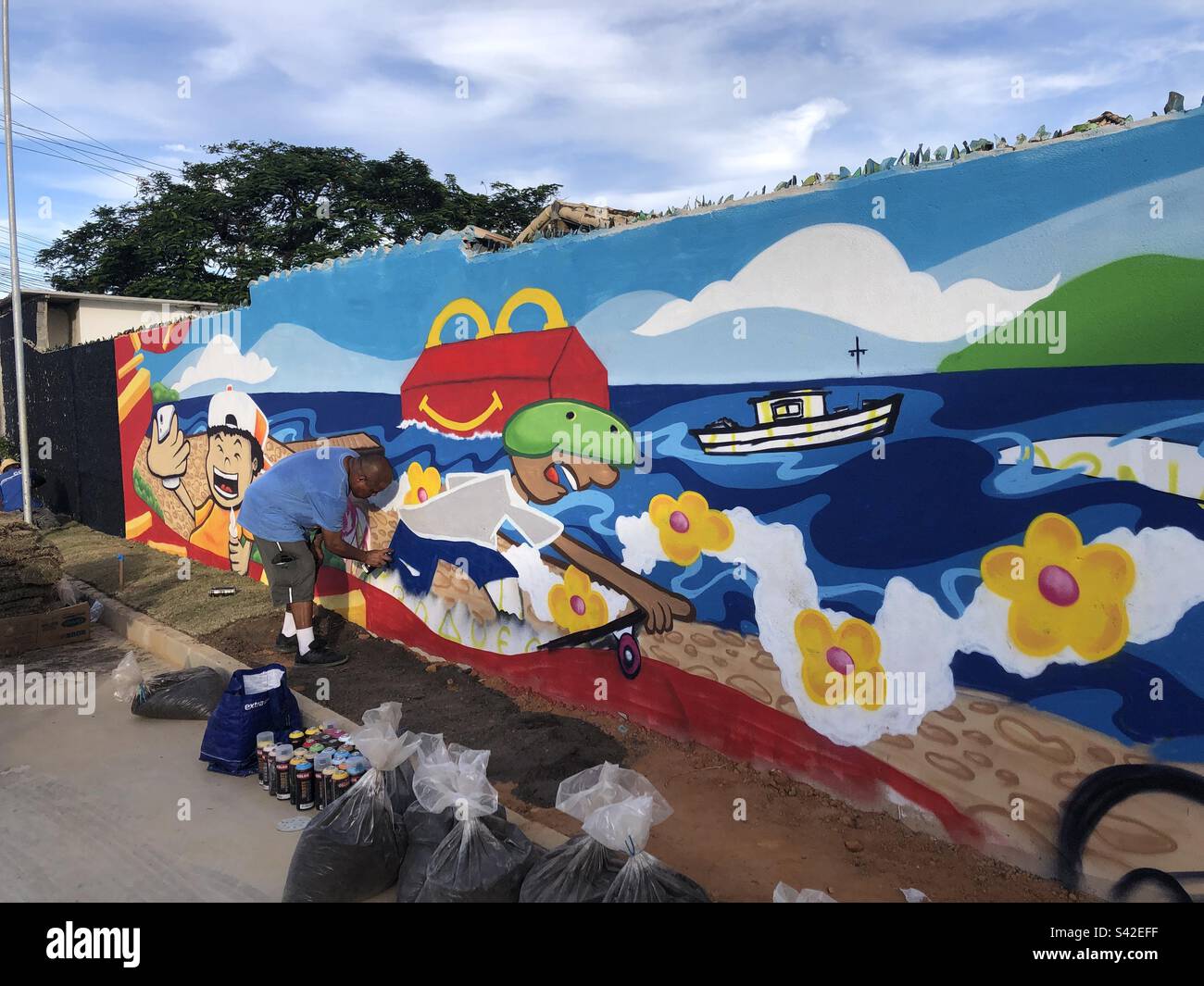 Artist spray painting a mural in Buzios, Brazil. Stock Photo