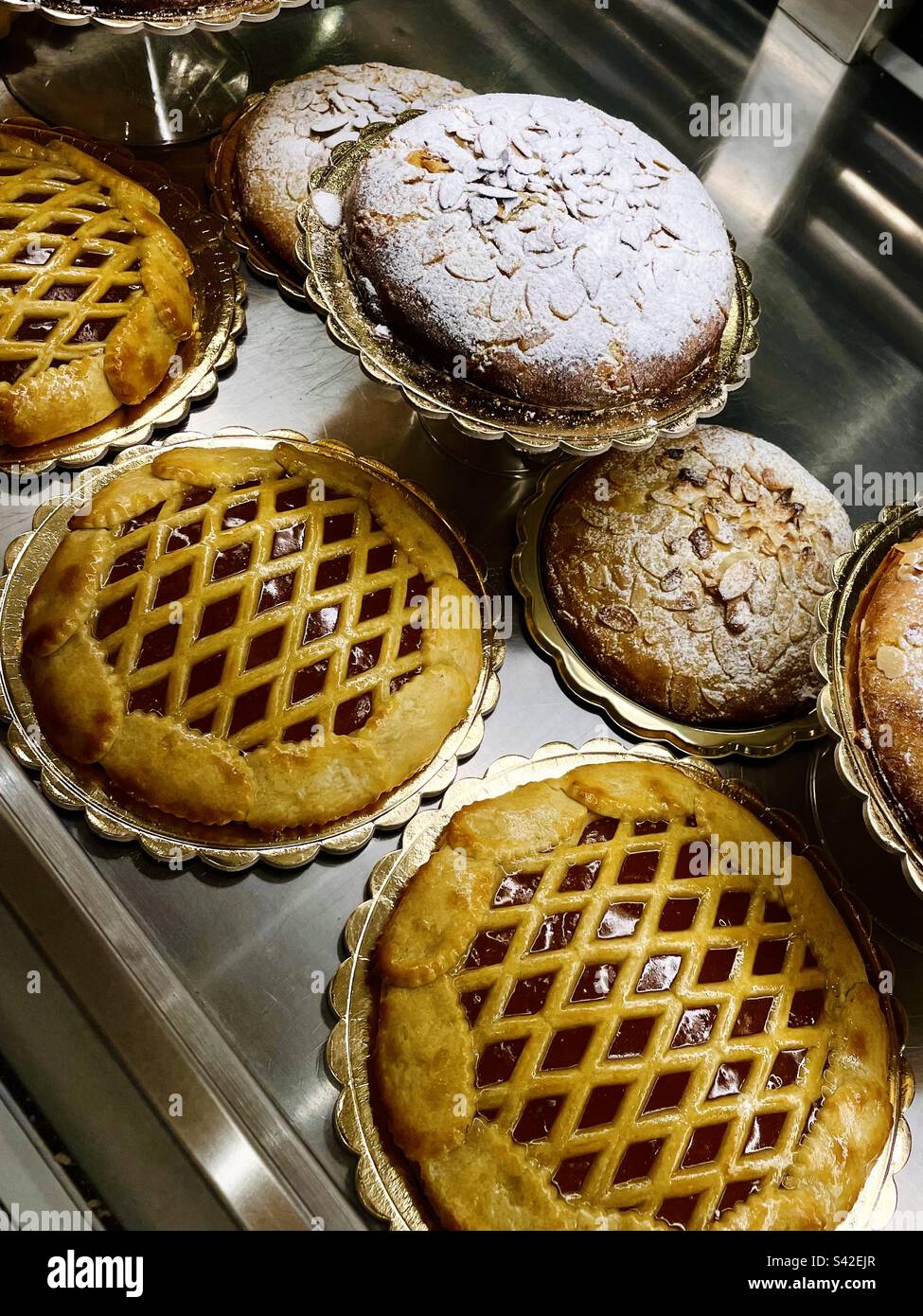 Different types of cakes and pies on display in a bakery shop Stock