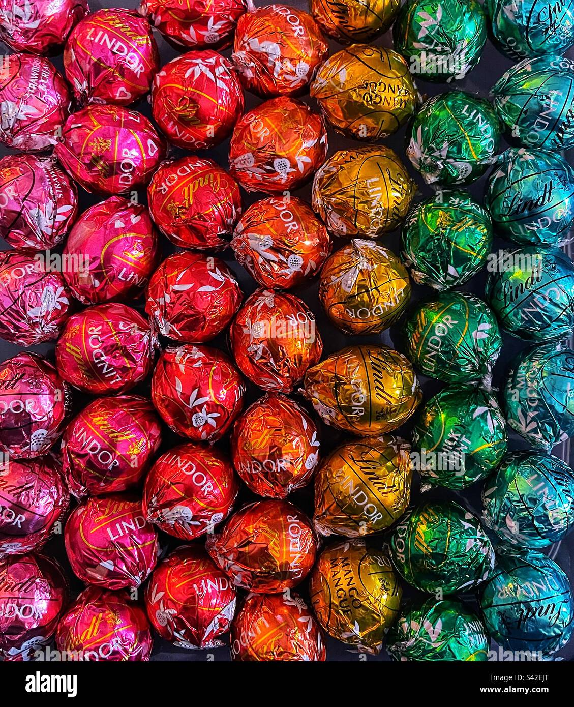 Lindt chocolate wrapped in colourful foils lined in a rainbow effect Stock Photo
