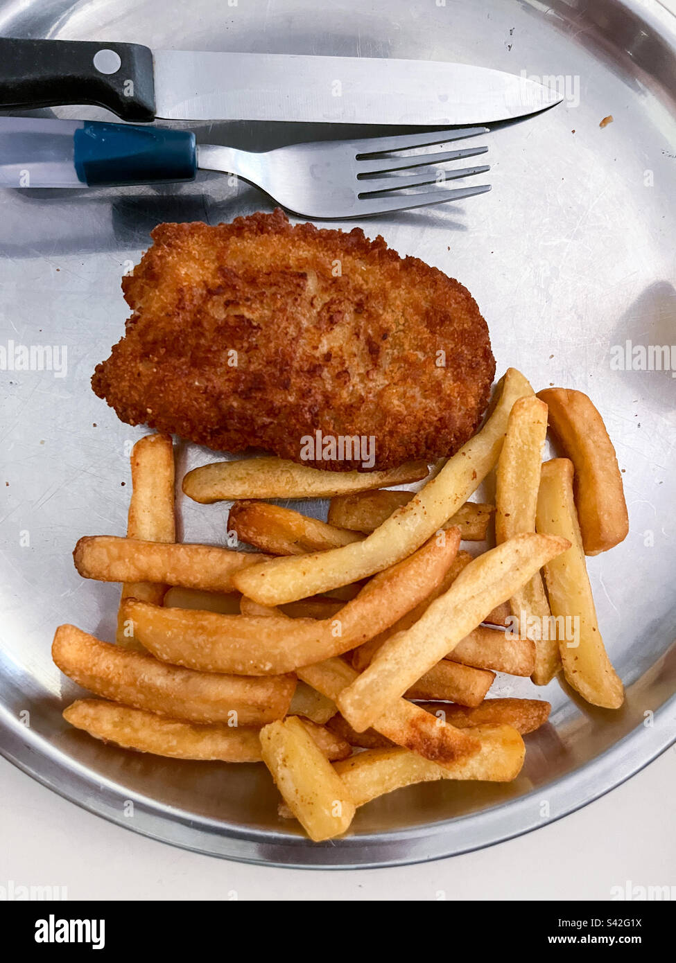 Fish and chips with fork and knife on stainless steel plate. - Smartphone Captured Stock Image