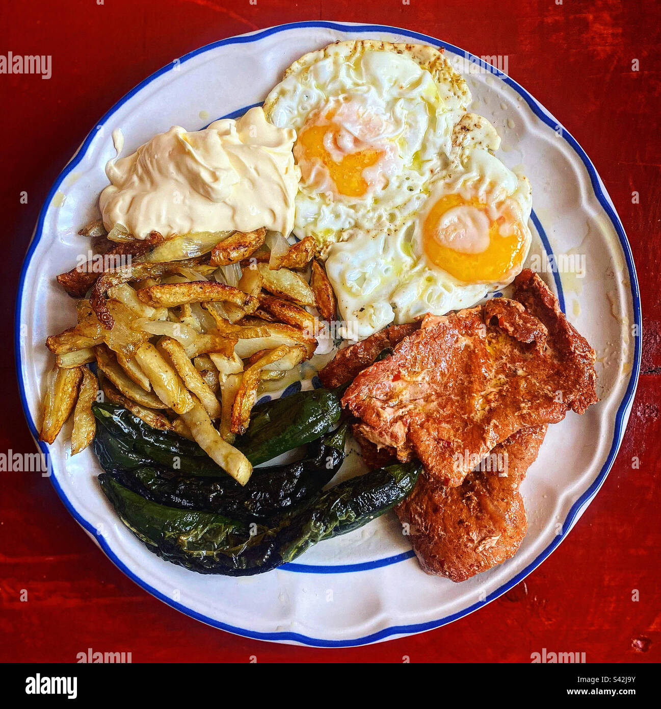 Two fried eggs, fried potatoes , fried green peppers and meat with chilli in Queretaro, Mexico - Smartphone Captured Stock Image