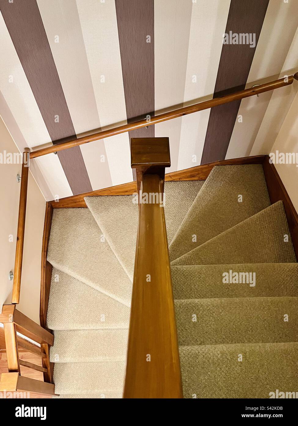 Stairwell with neutral carpet and striped wallpaper Stock Photo