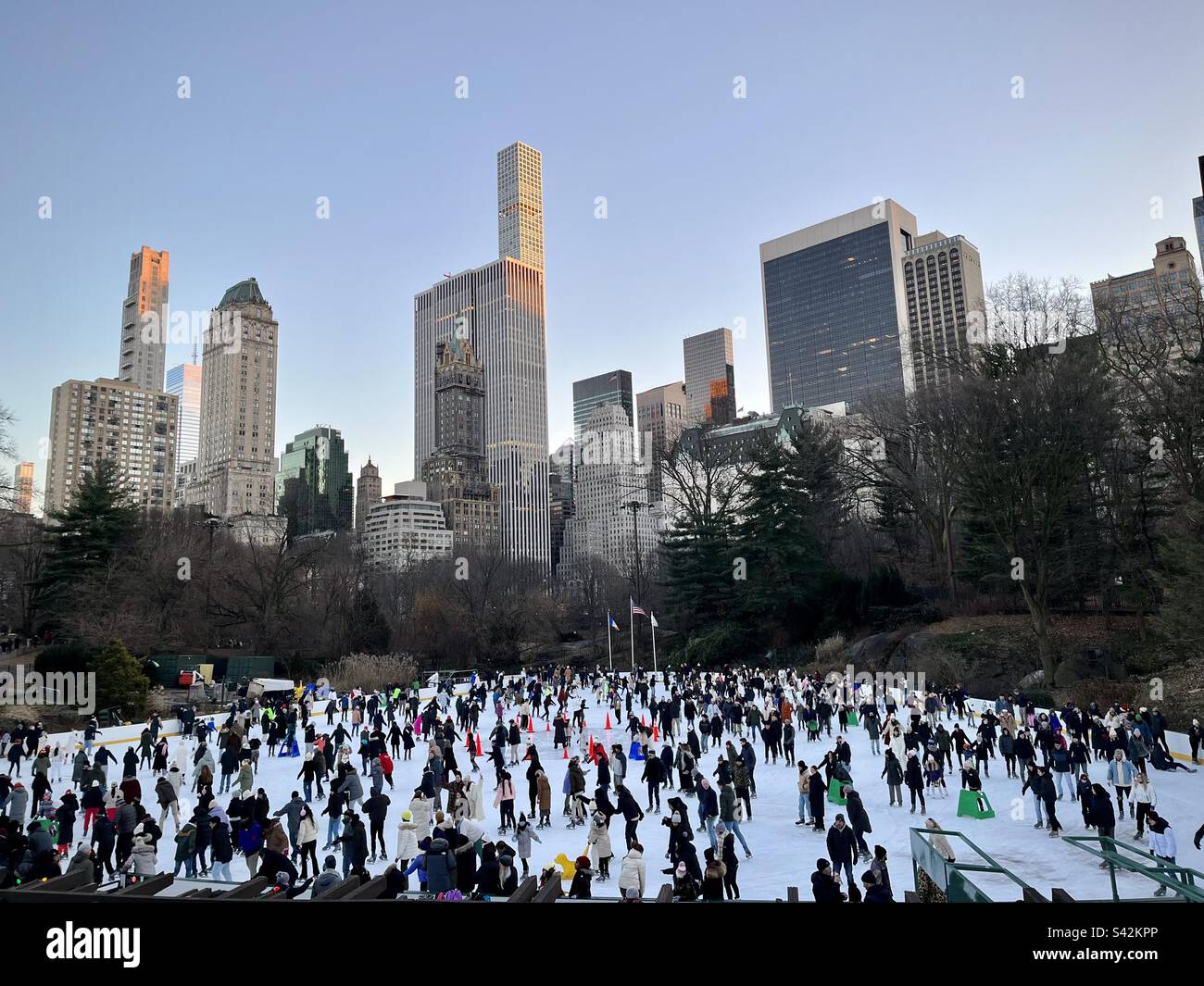 Central Park ice rink with a view of buildings. Photo taken in New York
