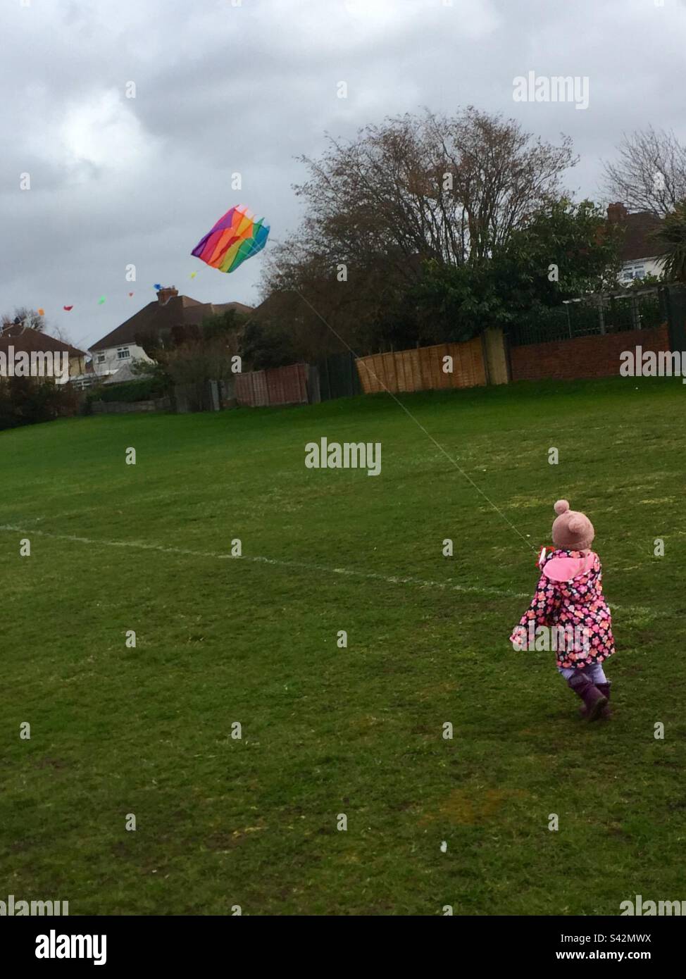 Toddler flying a colourful kite - Smartphone Captured Stock Image