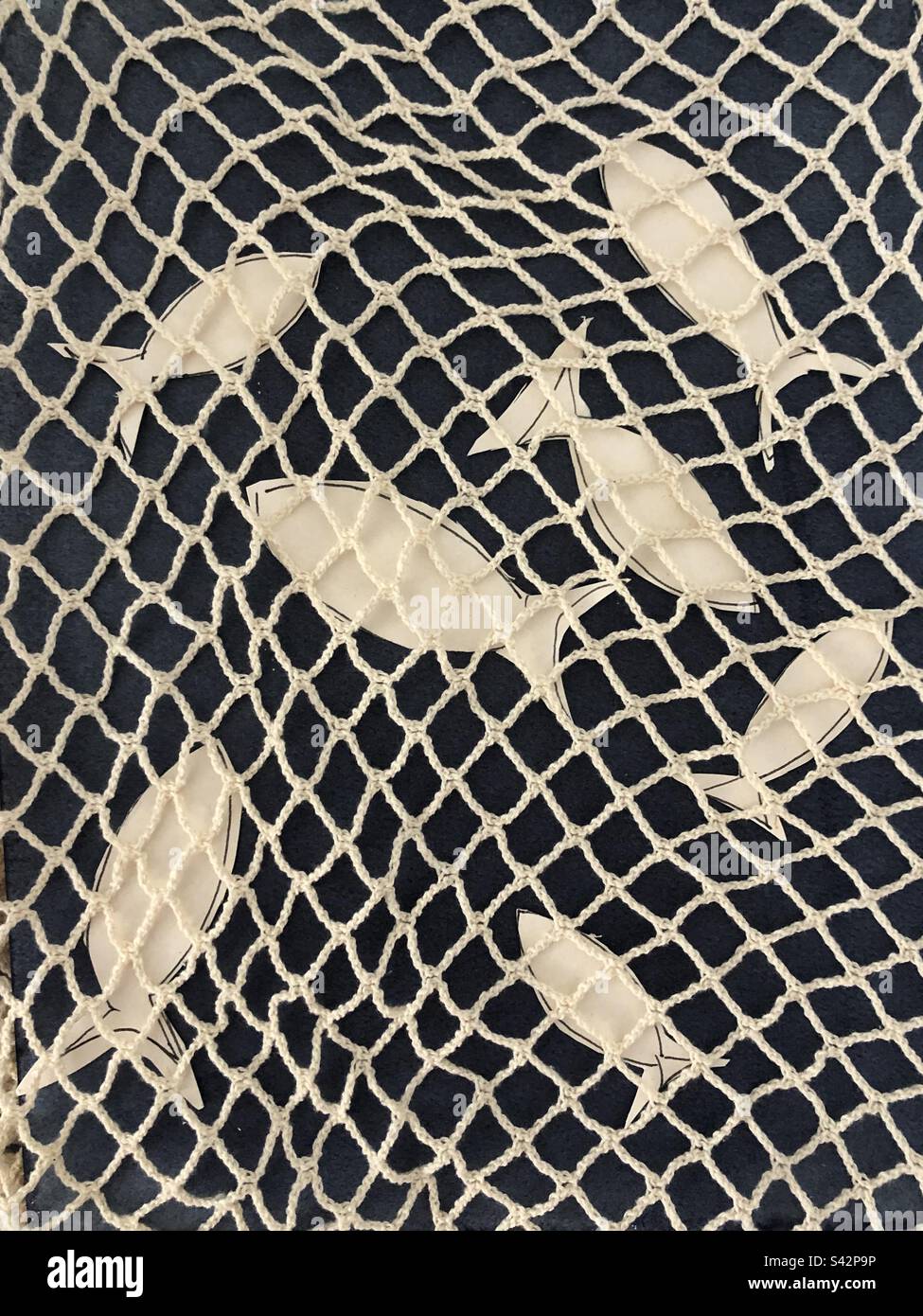 Cut out paper fish in a fishnet - Smartphone Captured Stock Image
