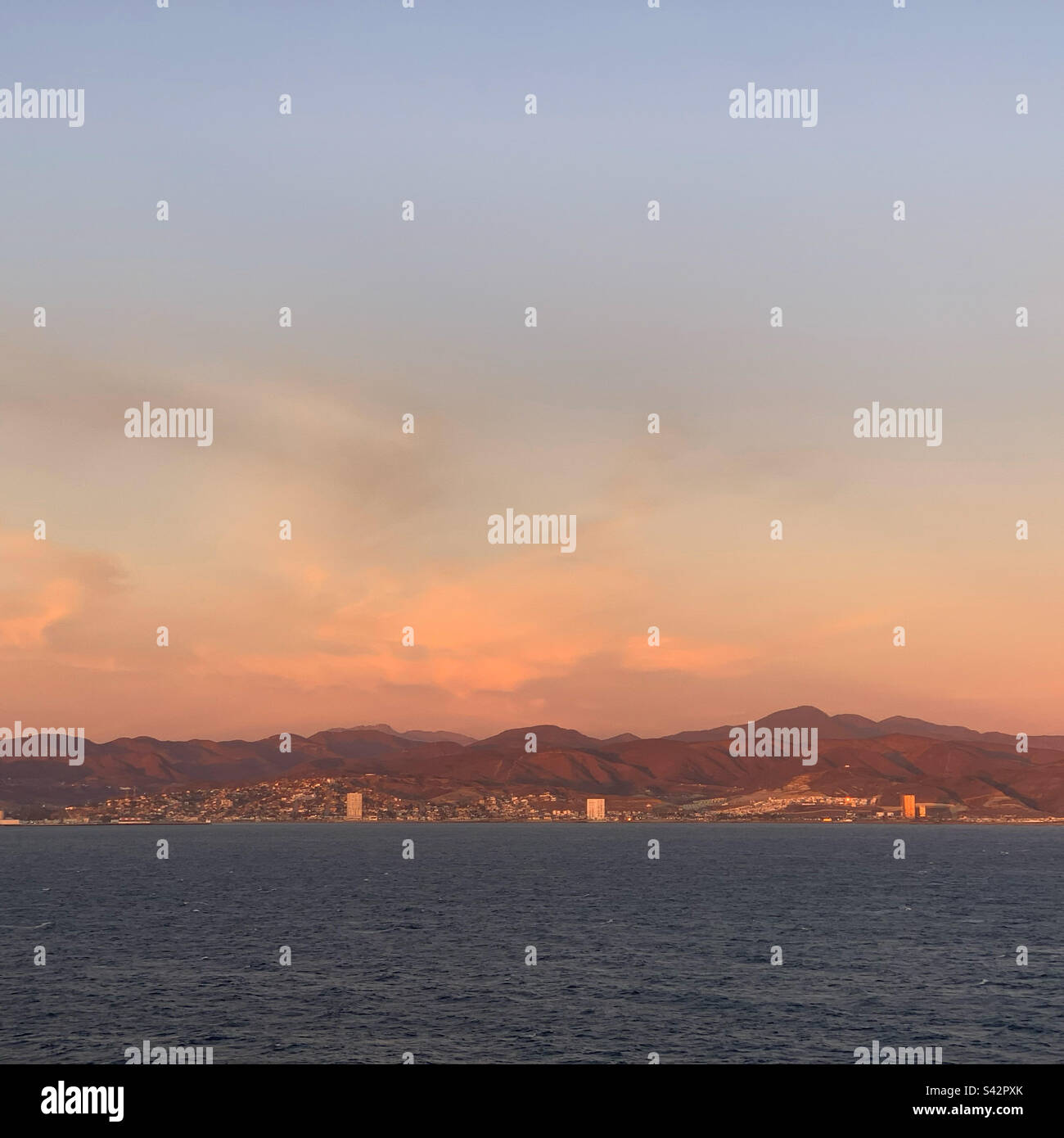 November, 2022, sunset view from a cruise ship leaving Ensenada, Baja California, Mexico - Smartphone Captured Stock Image