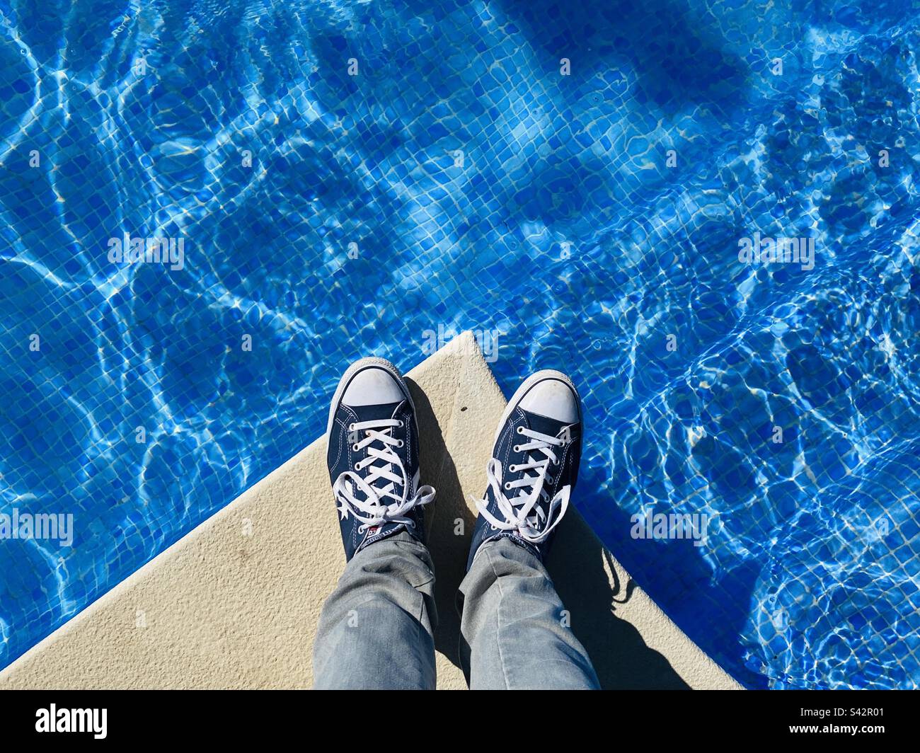 Lager Arkæolog læbe Looking down on feet wearing sneakers at the edge of a swimming pool Stock  Photo - Alamy
