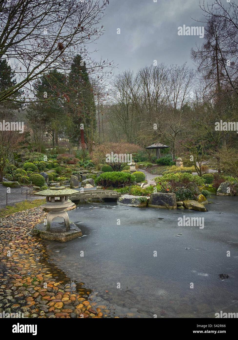 Japanese garden with stone lanterns and frozen ponds in Würzburg, Germany. - Smartphone Captured Stock Image