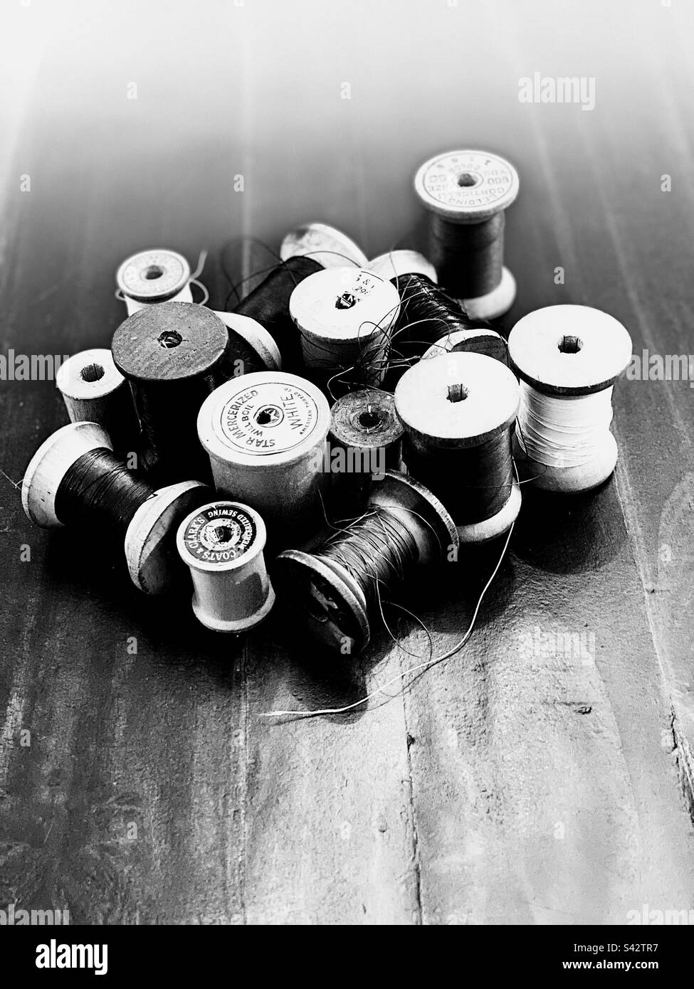 Vintage wooden spools of colorful thread in black and white. - Smartphone Captured Stock Image