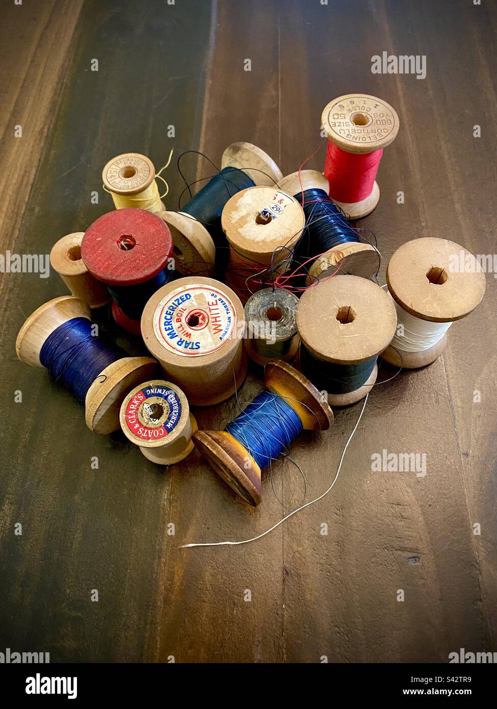 Vintage wooden spools of colorful thread. - Smartphone Captured Stock Image
