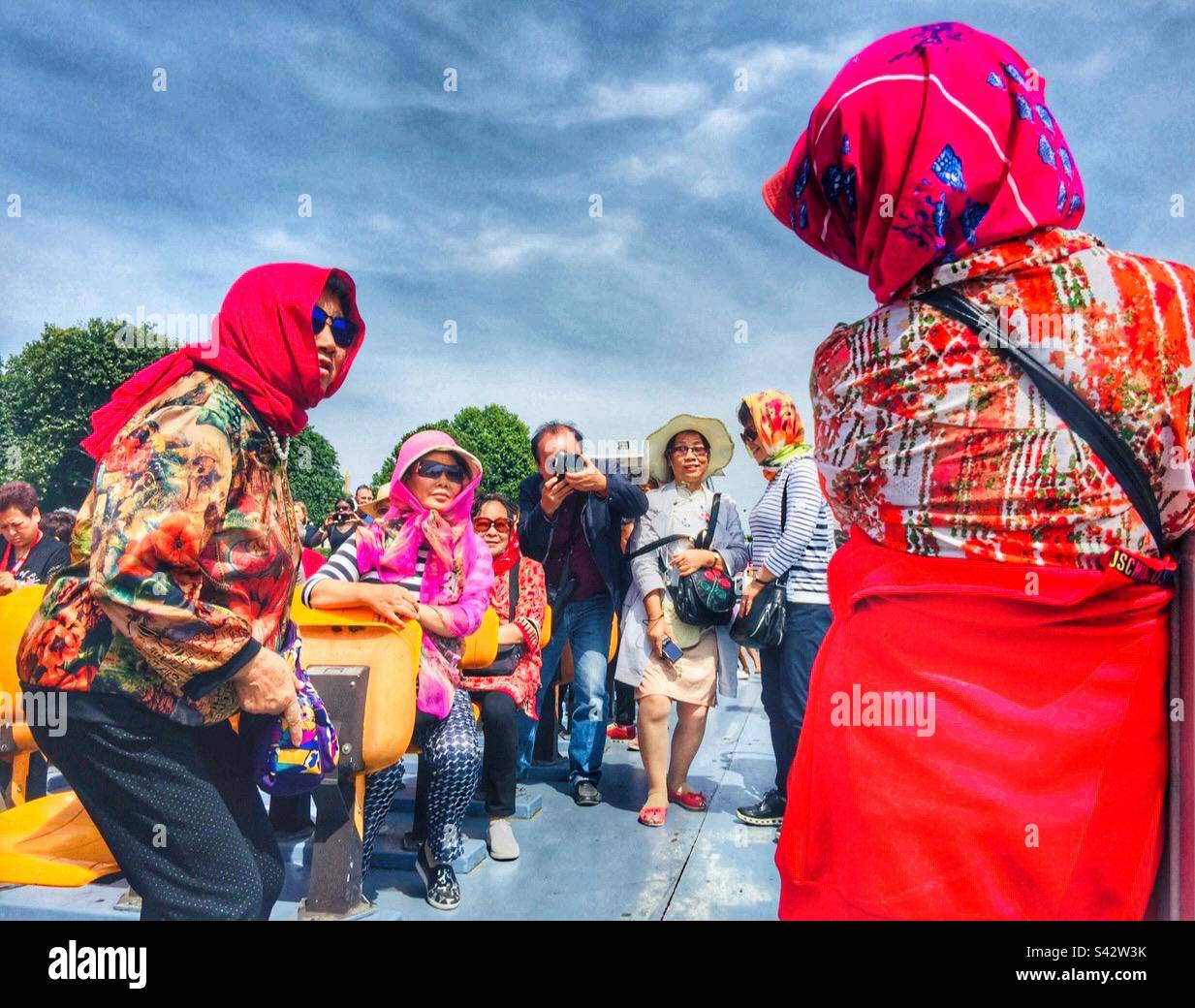 Colourful costumes in the bateau-mouche in Paris. Stock Photo