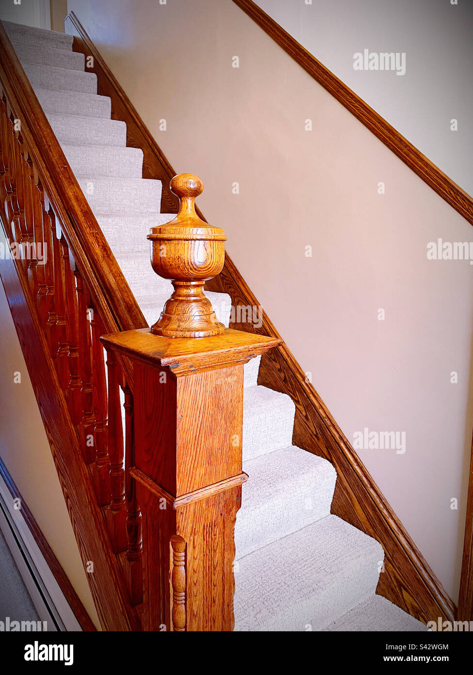Staircase with wooden banister and finial in a residential home, 2023, Bucks County