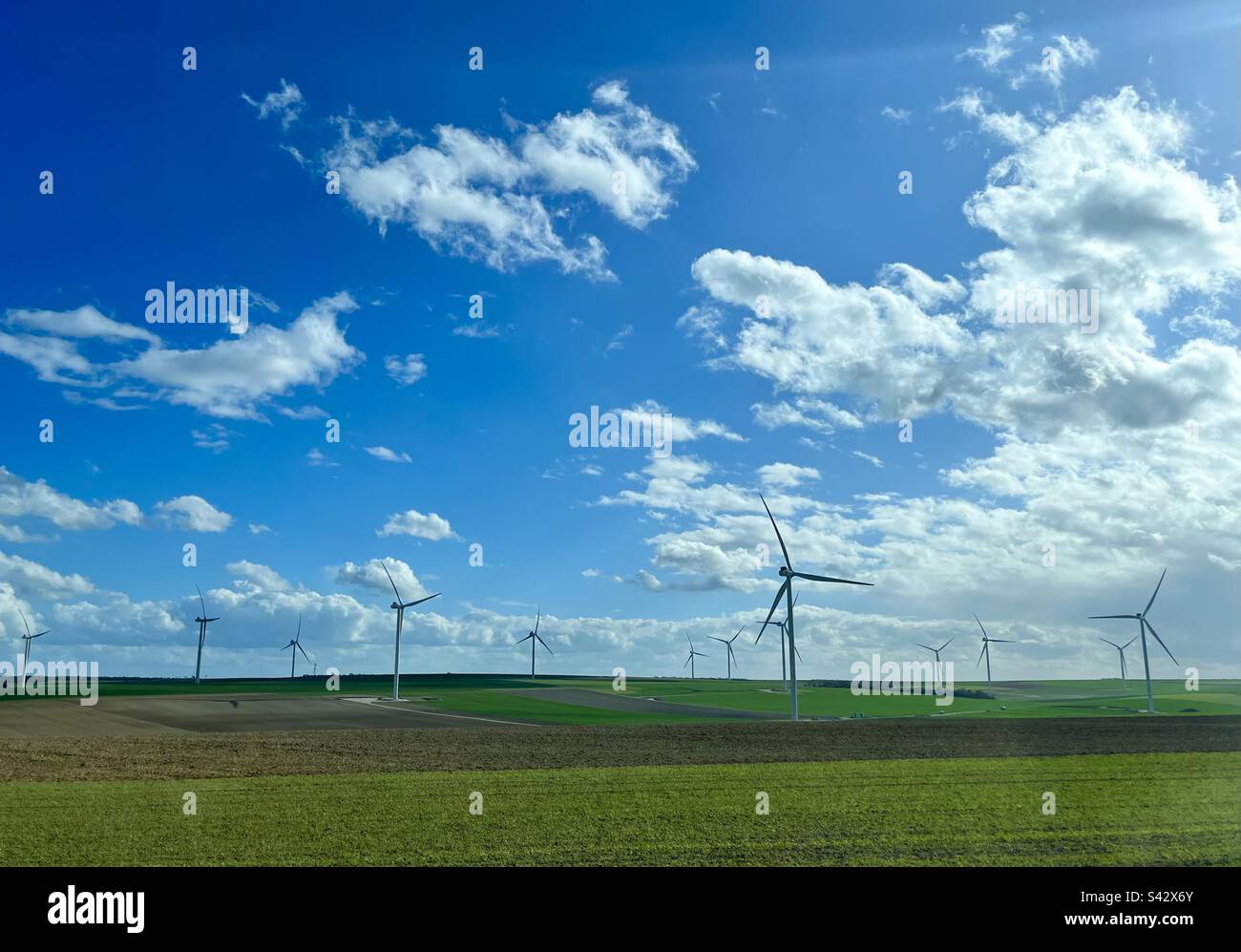 Wind turbine against a green field and blue sky Stock Photo - Alamy