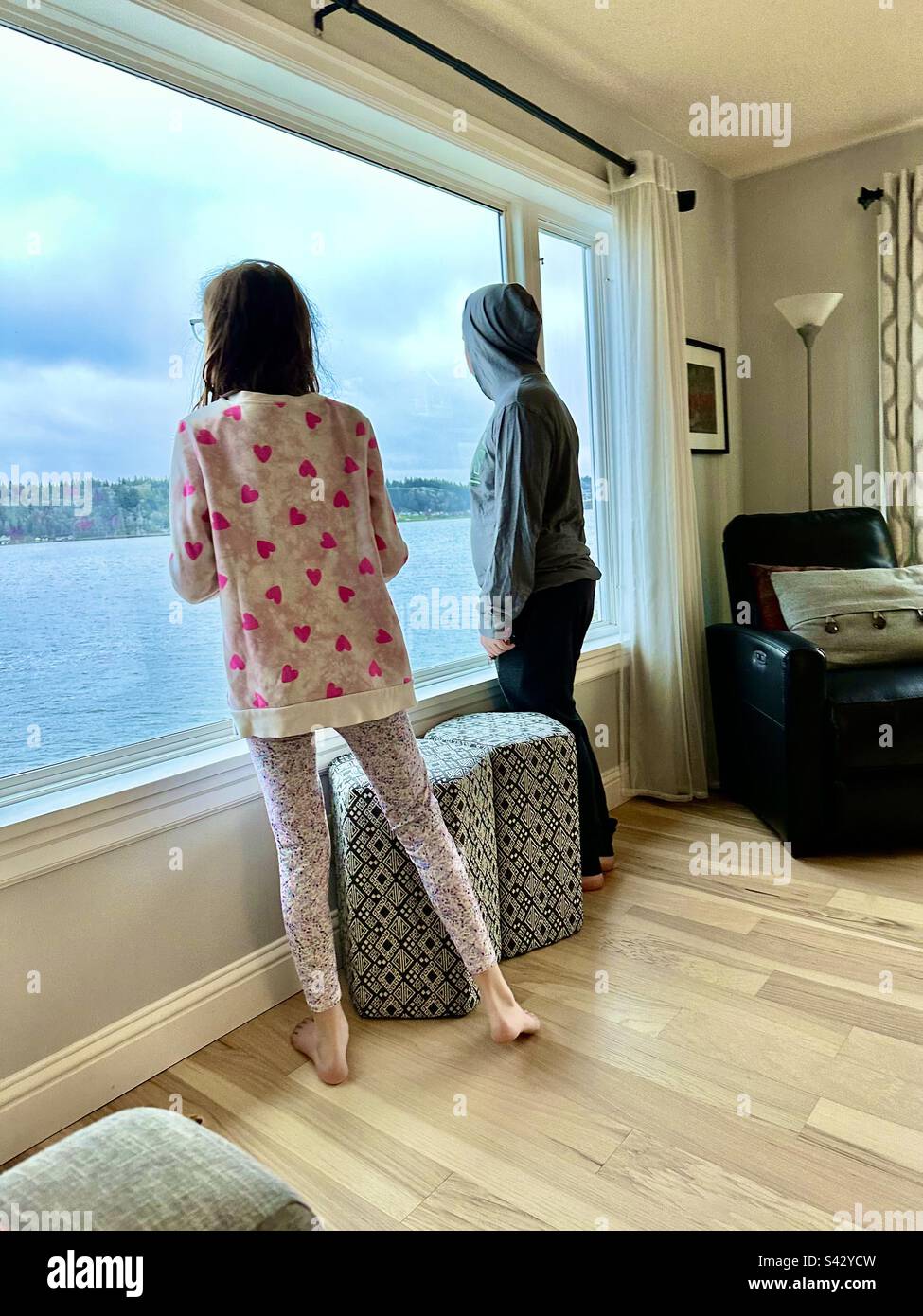 Kids looking out window Stock Photo