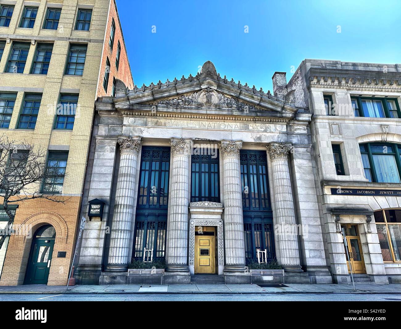 Former bank in between two other buildings in downtown, Norwich, Connecticut, USA. Grunge streetscape. - Smartphone Captured Stock Image