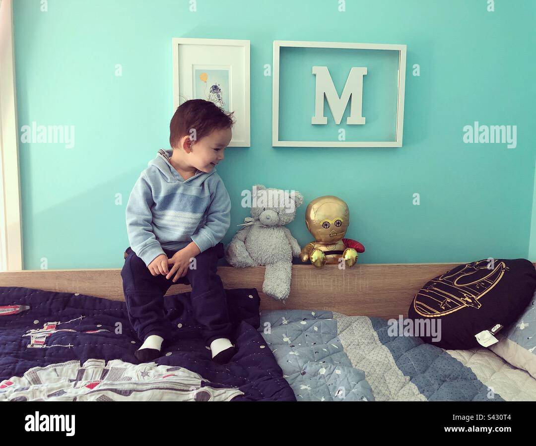 Boy sits with stuffed toys Stock Photo