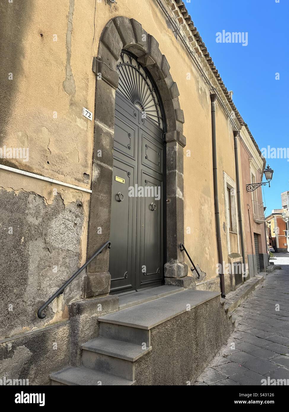 Home entrance with alley view, Adrano, Catania province, Sicily region, Italy - Smartphone Captured Stock Image