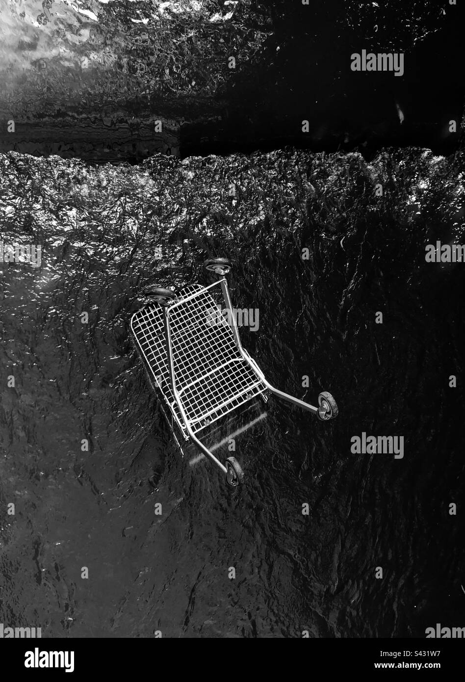 Shopping trolley thrown into a canal Stock Photo