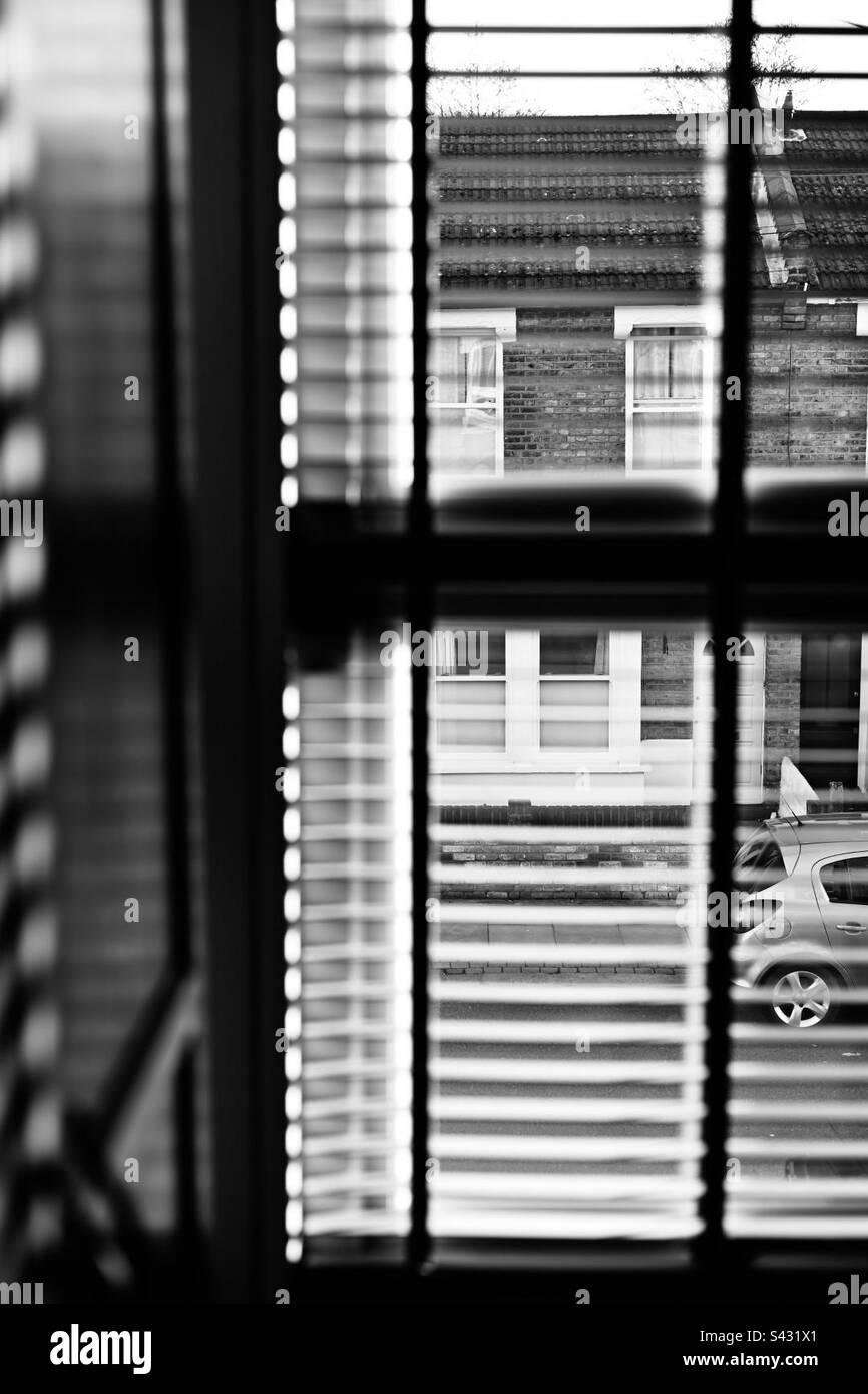 A view of UK terraced houses from inside a terraced house through blinds - Smartphone Captured Stock Image
