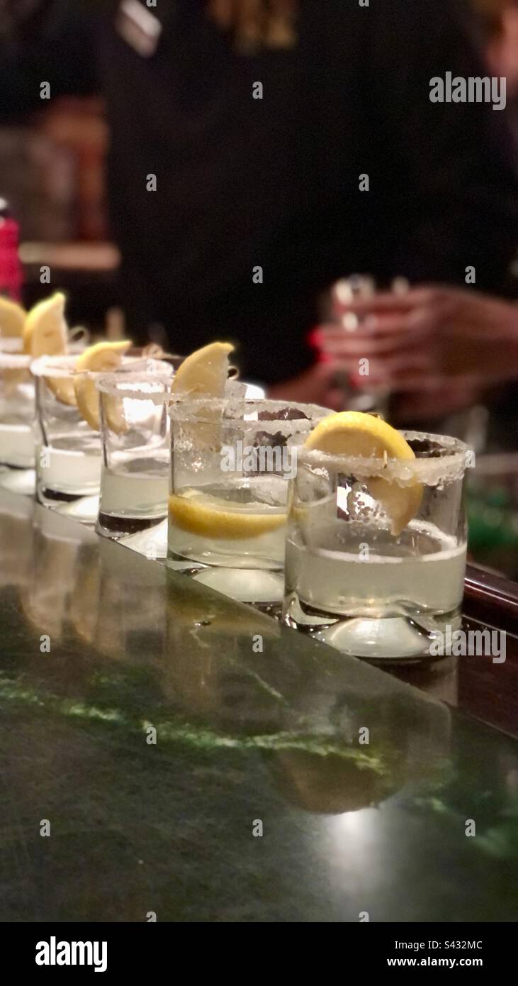 Drinks with salt and lemon sitting on a bar Stock Photo