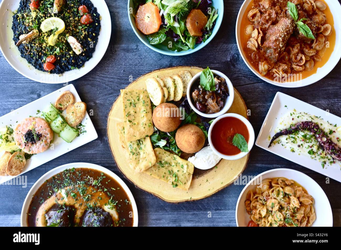 Food, table top view Italian cuisine. Sicilian specialties plated.  Octopus, risotto, Arancini, gnocchi, salad, - Smartphone Captured Stock Image