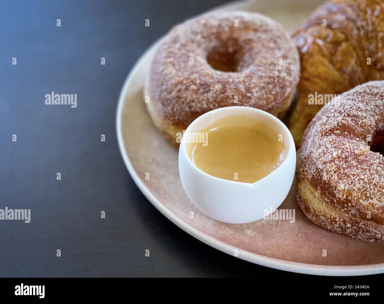 Close-up of cronuts and croissant and cup of expresso coffee on plate on table with copy space. - Smartphone Captured Stock Image
