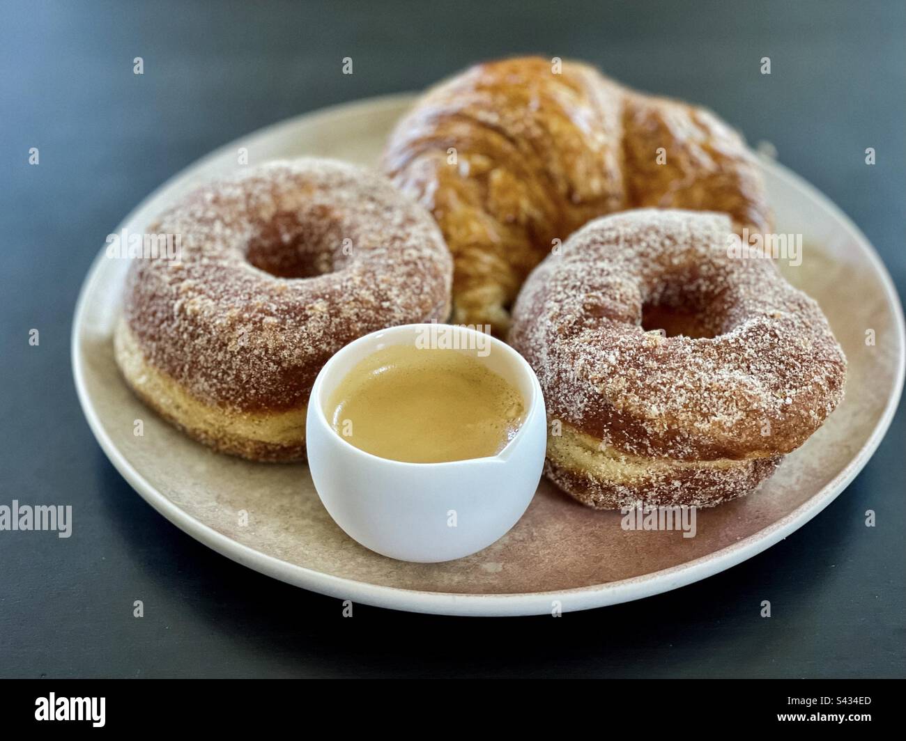 High angle, close-up view of cronuts, croissant and cup of expresso coffee on plate on table. - Smartphone Captured Stock Image