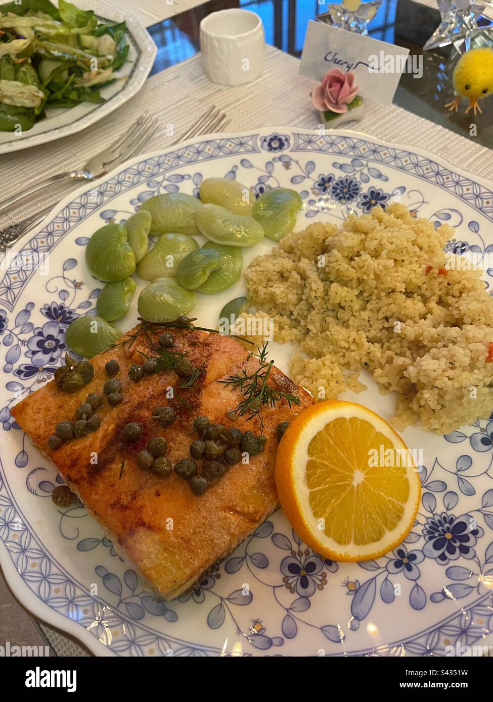 Close up of a formal dinner party plate filled with salmon fillet, fresh lima beans and couscous, 2023, New York City, USA - Smartphone Captured Stock Image