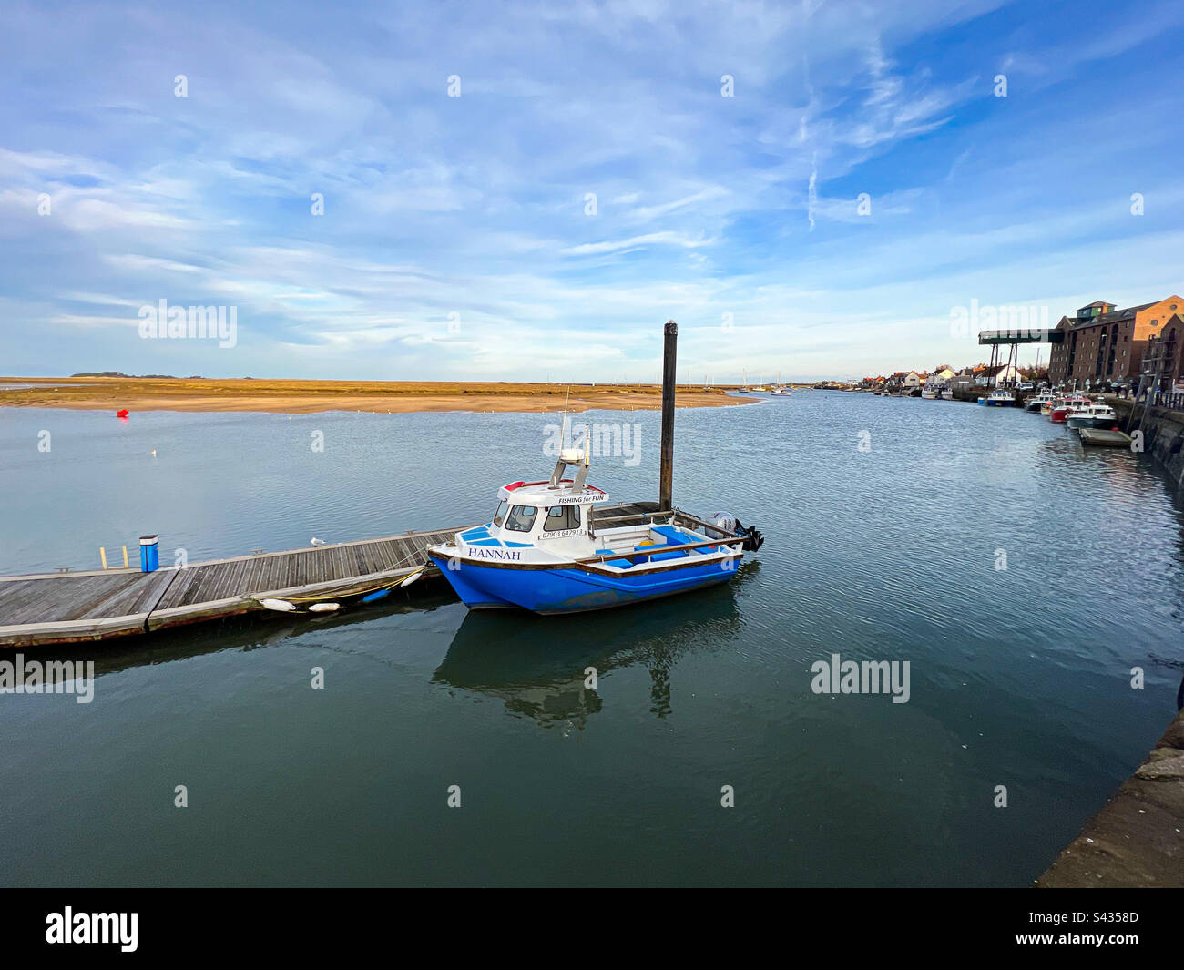 A single boat moored at Wells Next the Sea in North Norfolk, on a calm and sunny winter’s day. - Smartphone Captured Stock Image