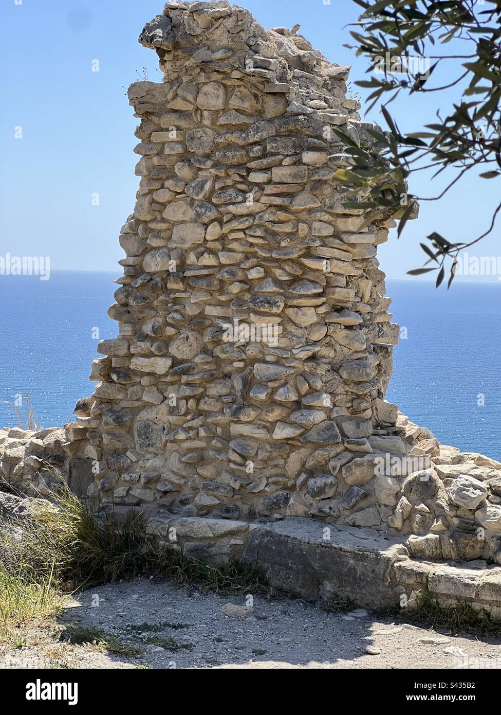 Historical temple wall with olive tree in the foreground Stock Photo