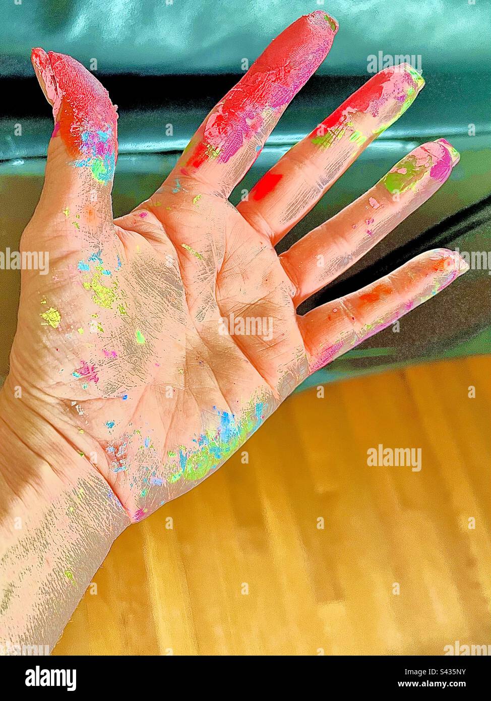 Graphic closeup of Caucasian hand with open palm and fingers messy with paint. Includes print space. Stock Photo