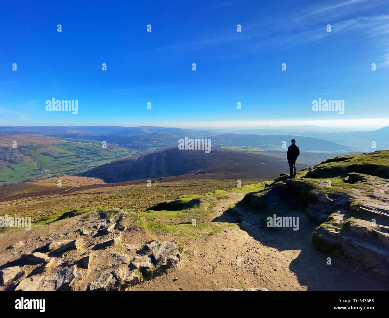 Lone walker enjoying the view from the Sugarloaf mountain, Brecon Beacons, Abergavenny, Wales, early morning, April. - Smartphone Captured Stock Image