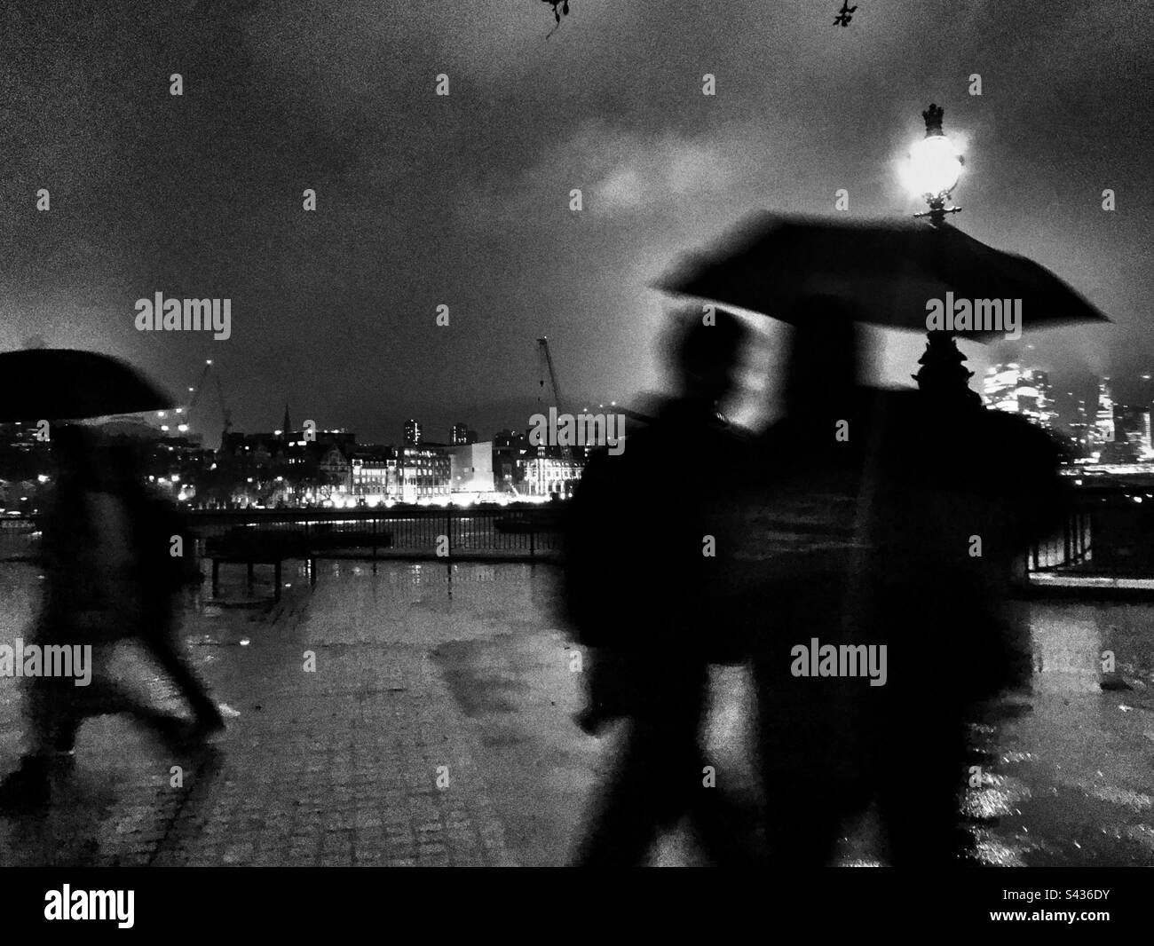 Night rain and people walking with their umbrellas by the Southbank of ...