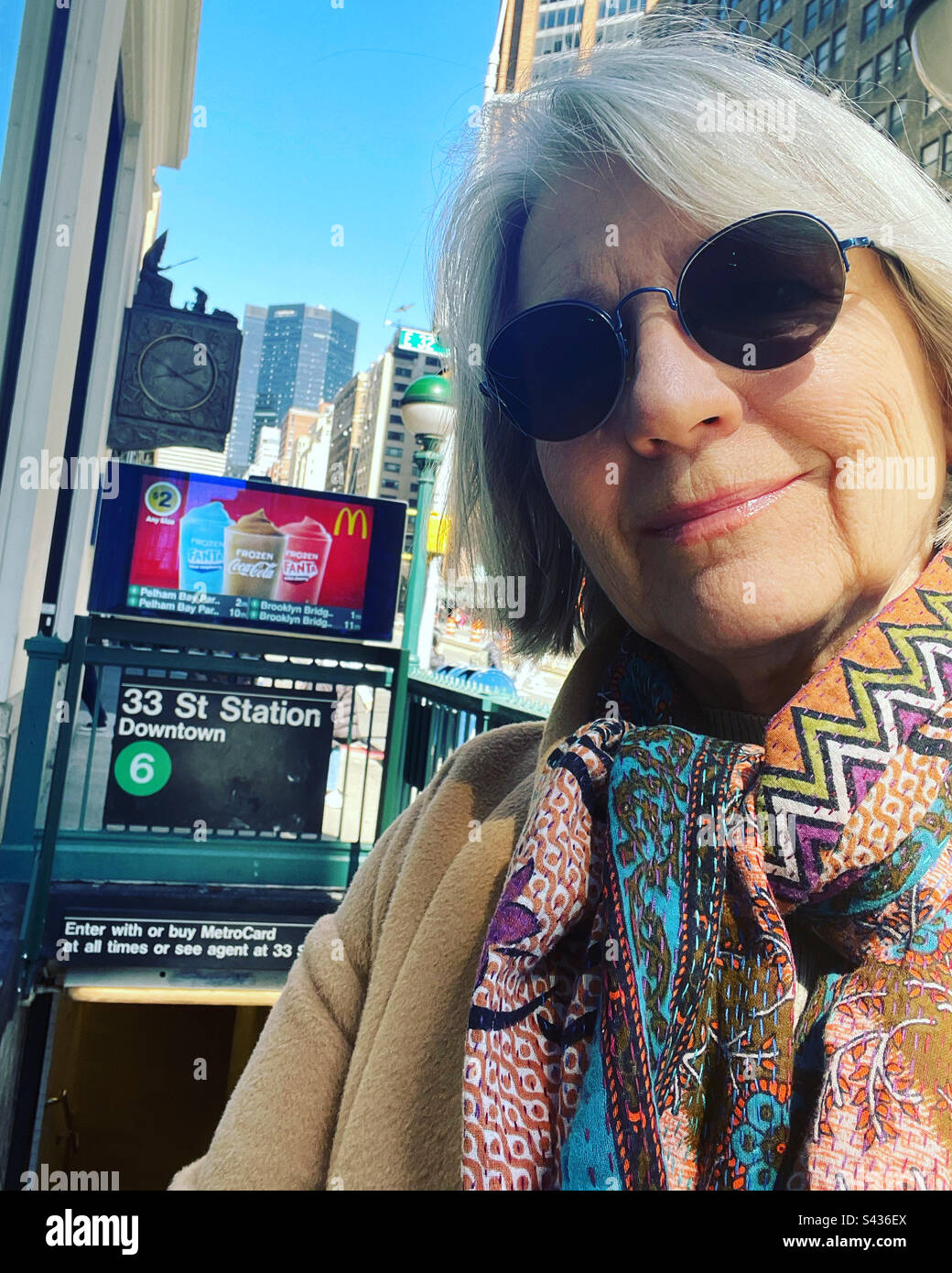 Woman in sunglasses at entrance of a subway station in New York - Smartphone Captured Stock Image