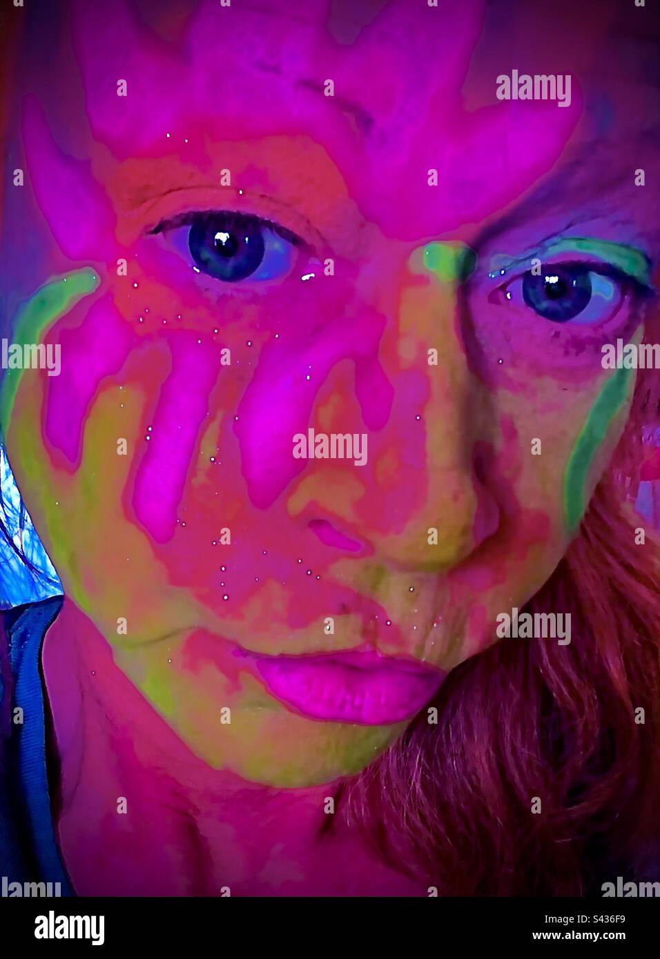 Painted Face. Closeup portrait of woman’s face with bright colored neon face paint. Stock Photo