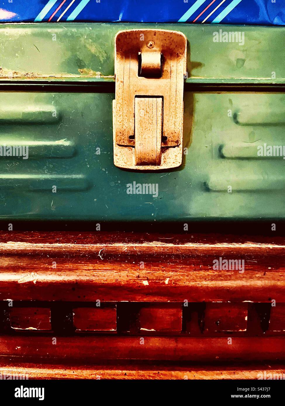 Green lock box with gold latch on textured wooden surface. Includes print space. - Smartphone Captured Stock Image