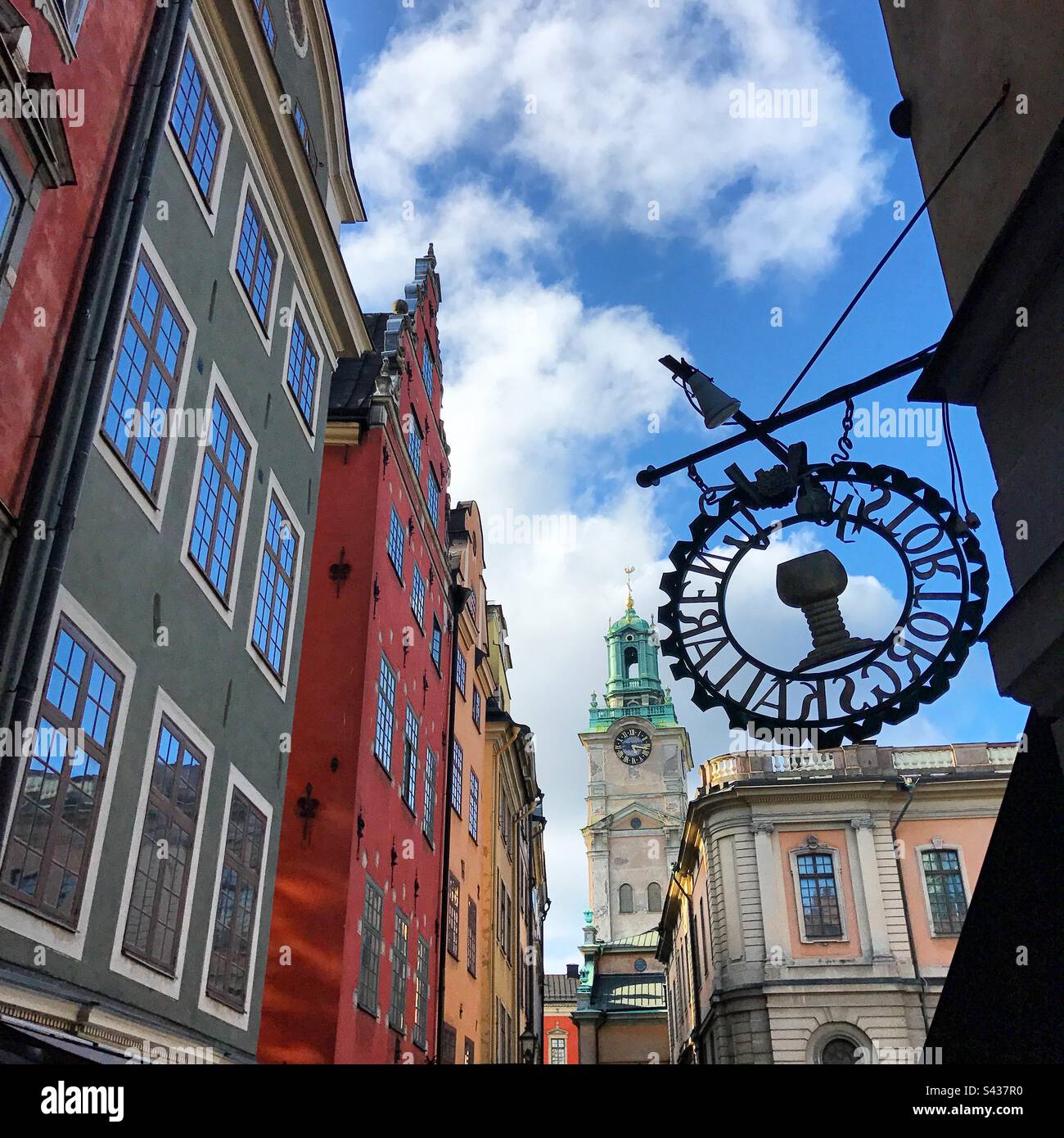 The beautiful shadowy red, green, orange and yellow painted exteriors of traditional buildings on the narrow streets of Stockholm Old Town Gamla Stan in Sweden - Smartphone Captured Stock Image