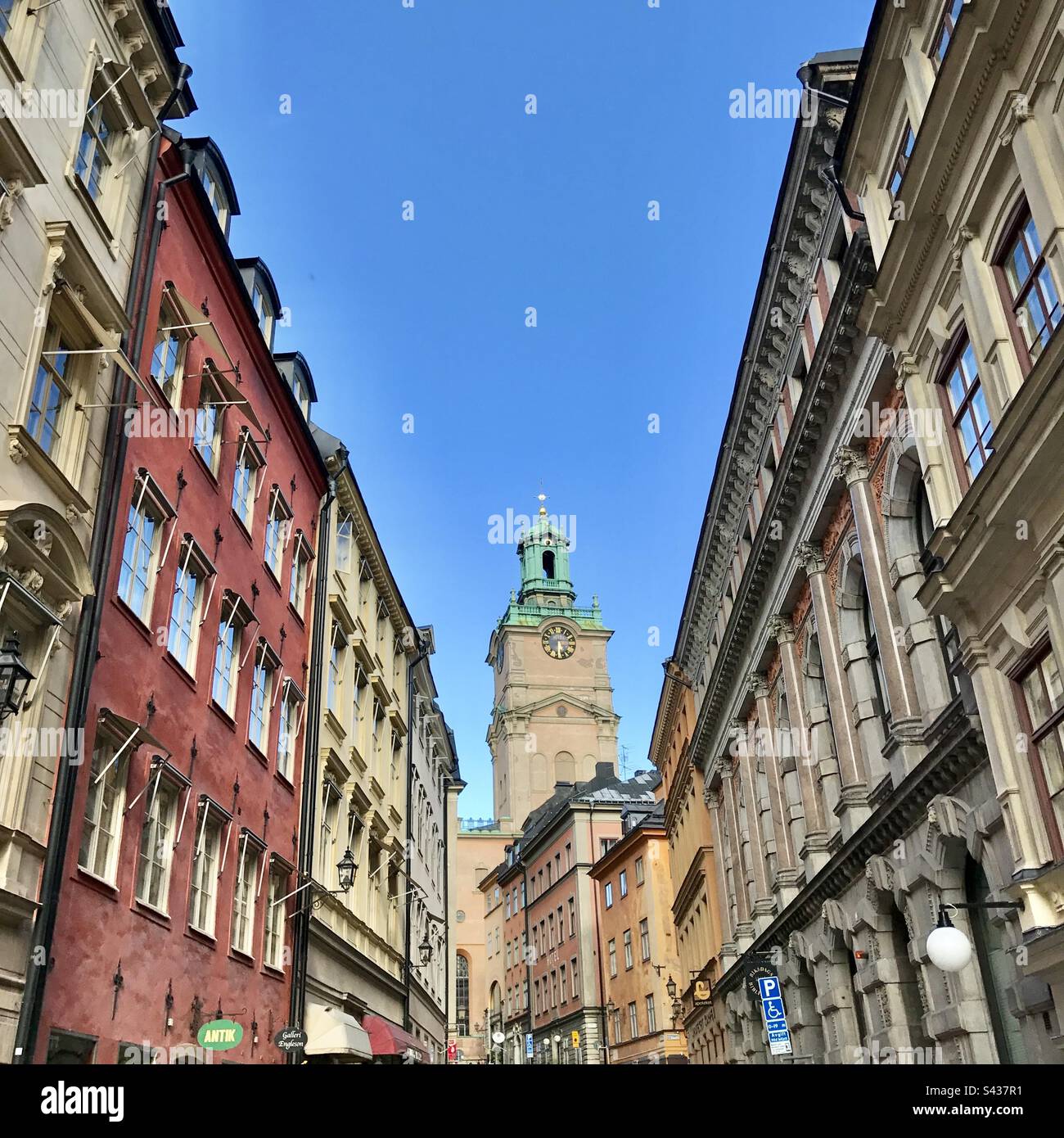 The beautiful red, orange and yellow painted exteriors of traditional buildings on the narrow streets of Stockholm Old Town Gamla Stan in Sweden - Smartphone Captured Stock Image
