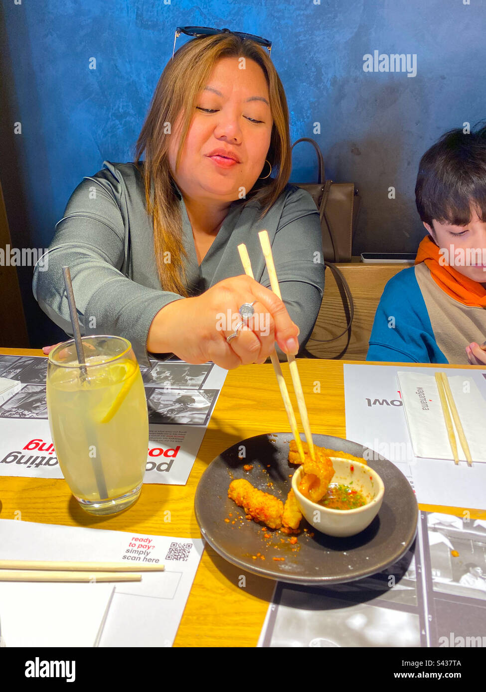 A lady enjoying a squid starter in a restaurant Stock Photo