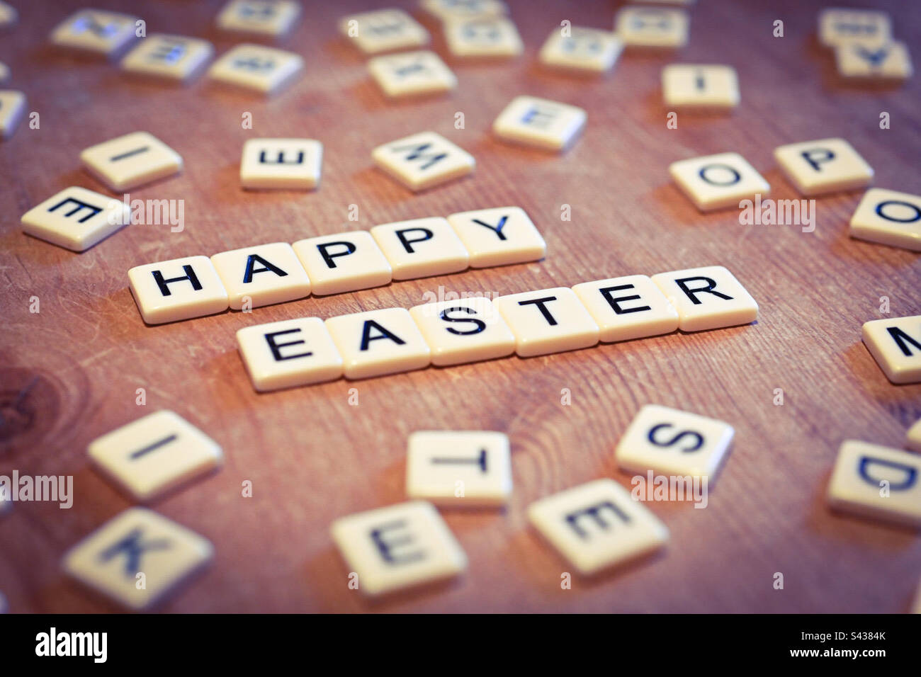 Happy Easter written in scrabble letters on a kitchen table - Smartphone Captured Stock Image