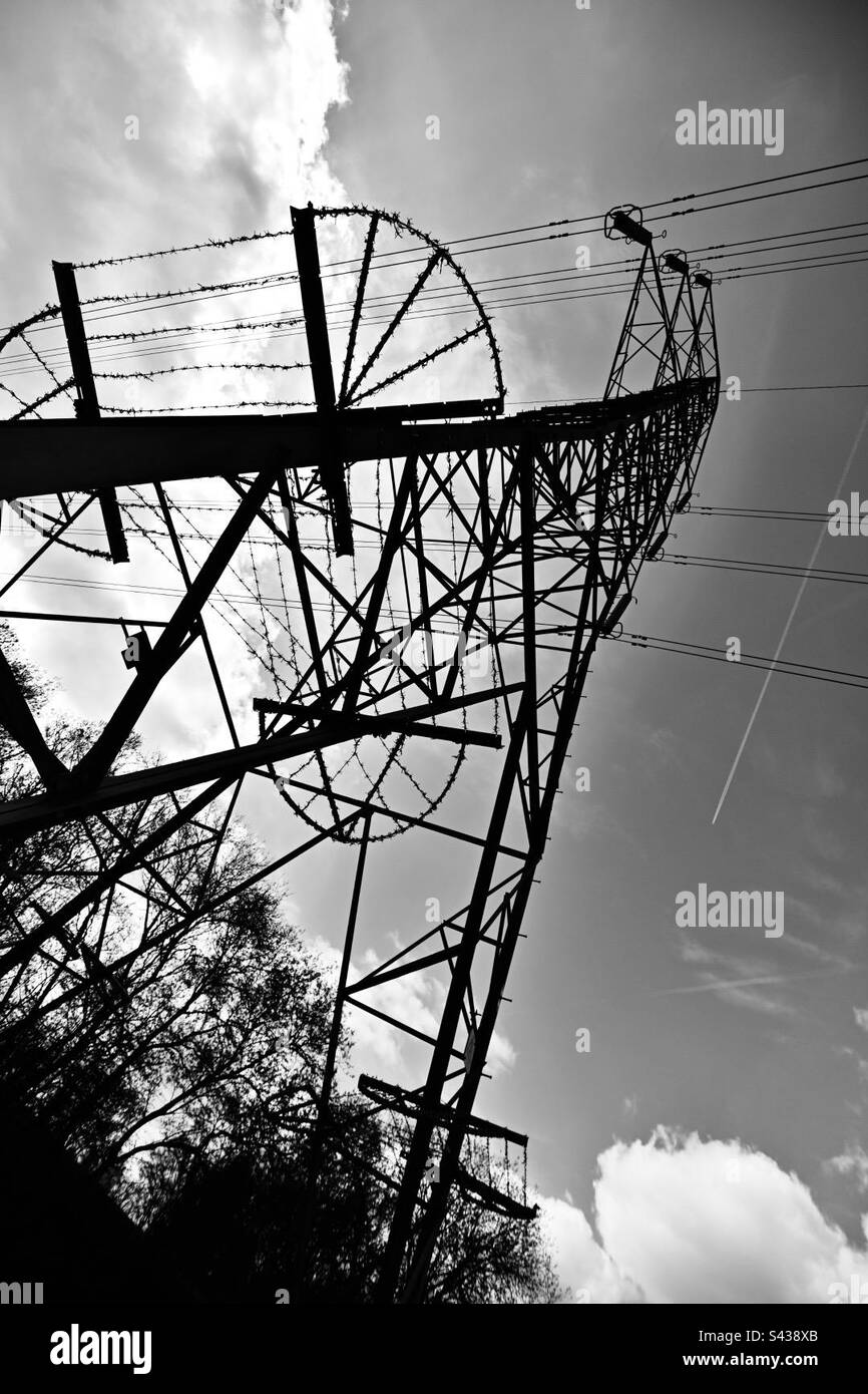 An electricity pylon with high voltage cables and barbed wire protecting it from climbers - Smartphone Captured Stock Image