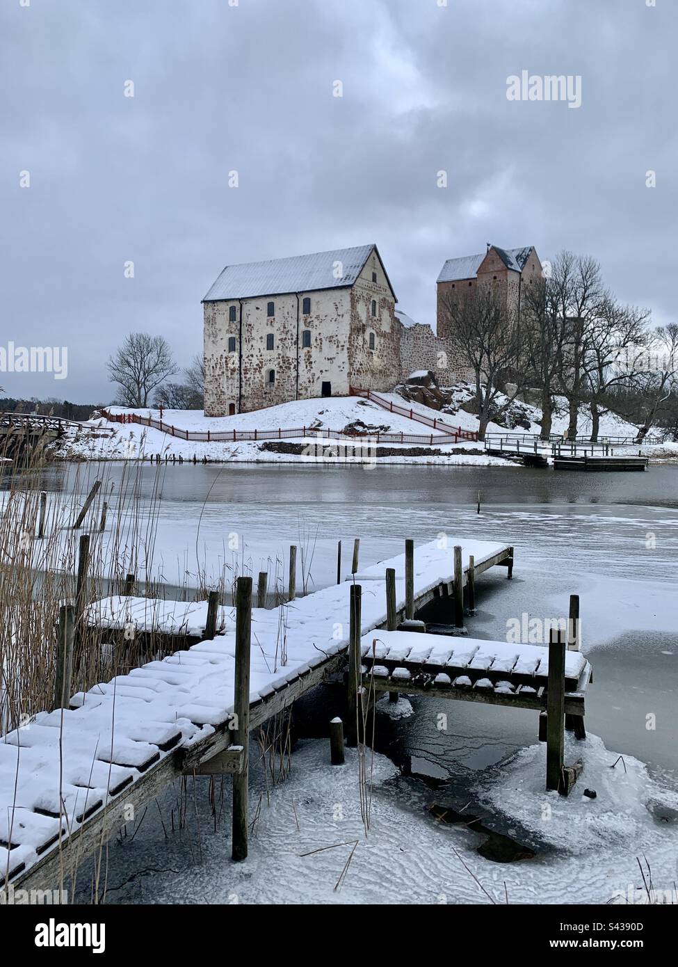 The beautiful ancient castle of Kastelholm in the Åland Islands archipelago in the Baltic Sea region of Finland in deep winter. Viewed over a decaying pier on an inland sea lake - Smartphone Captured Stock Image The beautiful ancient castle of Kastelholm in the Åland Islands archipelago in the Baltic Sea region of Finland in deep winter. Viewed over a decaying pier on an inland sea lake - Smartphone Captured Stock Image