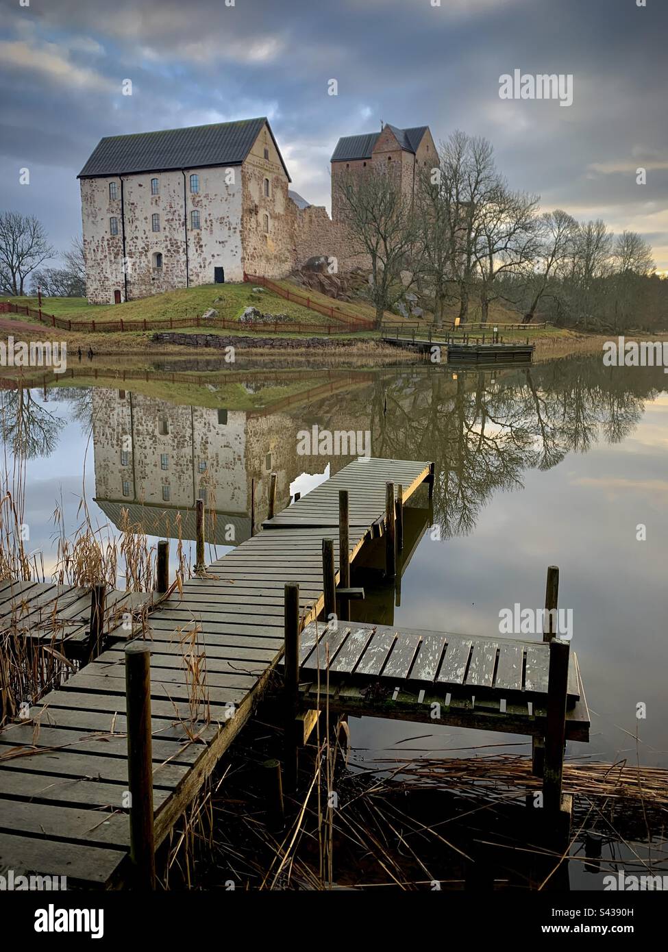 The beautiful ancient castle of Kastelholm in the Åland Islands archipelago in the Baltic Sea region of Finland in autumn. Viewed over a decaying pier on an inland sea lake - Smartphone Captured Stock Image The beautiful ancient castle of Kastelholm in the Åland Islands archipelago in the Baltic Sea region of Finland in autumn. Viewed over a decaying pier on an inland sea lake - Smartphone Captured Stock Image