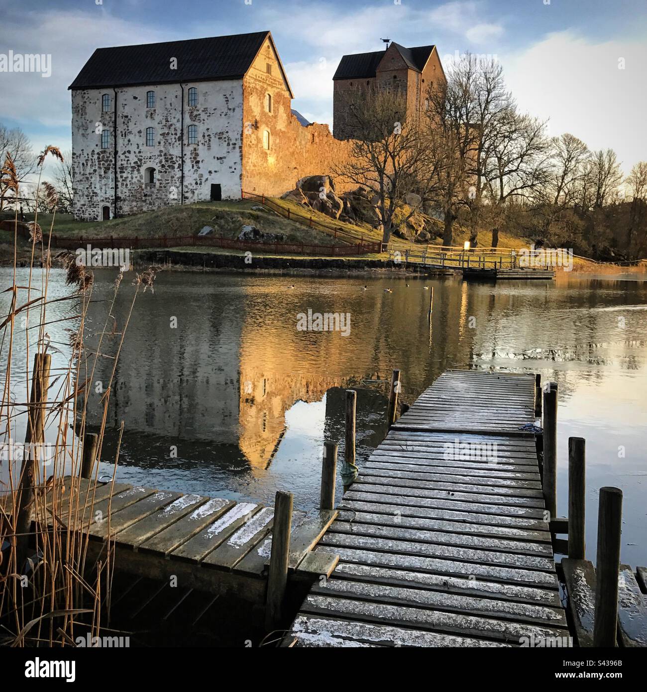 The beautiful ancient castle of Kastelholm in the Åland Islands archipelago in the Baltic Sea region of Finland in winter. Viewed over a decaying pier on an inland sea lake - Smartphone Captured Stock Image The beautiful ancient castle of Kastelholm in the Åland Islands archipelago in the Baltic Sea region of Finland in winter. Viewed over a decaying pier on an inland sea lake - Smartphone Captured Stock Image