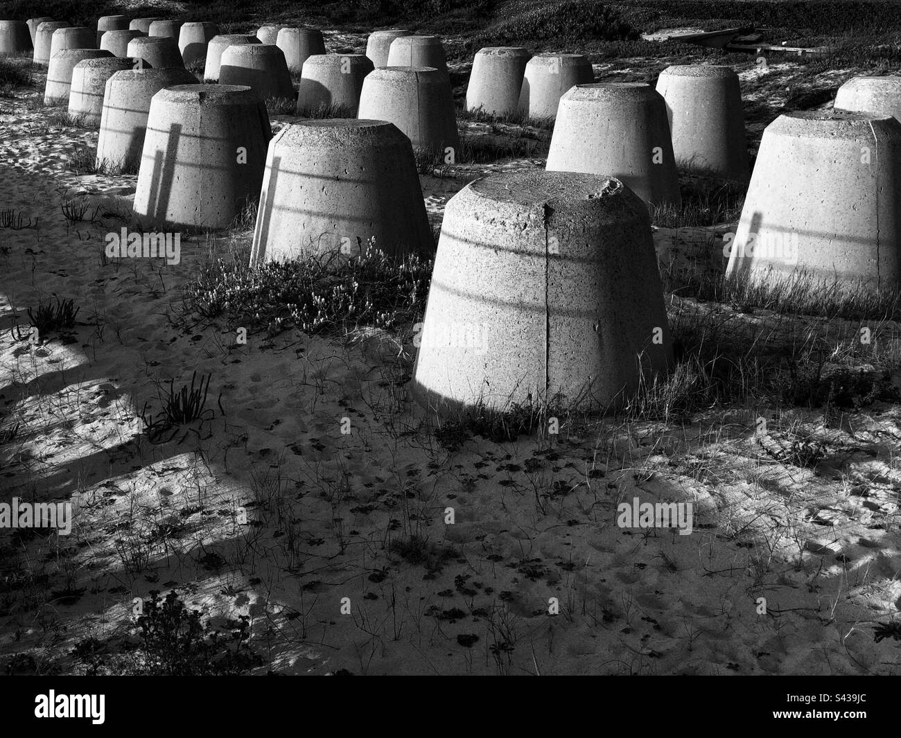 Monochrome image of the concrete boulders set to protect sand dunes on the shoreline of Portugal, 2023 - Smartphone Captured Stock Image